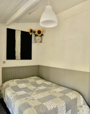 a bedroom with a bed and a vase of flowers at La campagne dans la ville in Narbonne