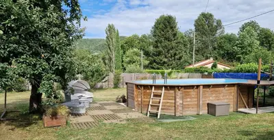 a wooden building with a pool in a yard at Gîte Tintinnabule in Ventenac