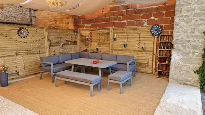 a table and chairs in a room with a brick wall at Gîte Tintinnabule in Ventenac