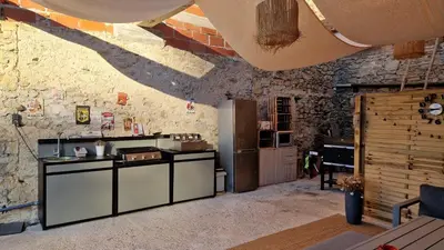 a kitchen with a counter and a refrigerator in a room at Gîte Tintinnabule in Ventenac