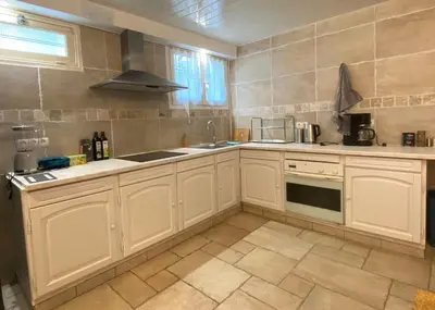 a kitchen with white cabinets and a sink at Maison avec 2 appartements, jacuzzi et accès privé à la rivière in Ladern-sur-Lauquet