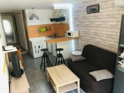 a living room with a couch and a kitchen at La Barbacane in Lapalme