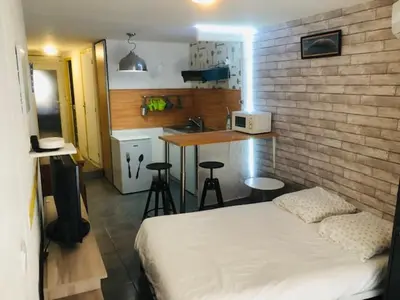 a bedroom with a bed and a kitchen with a counter at La Barbacane in Lapalme