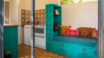 a kitchen with a blue cabinet with pillows on it at Les Cabanes d'ErbeFol in Ansignan