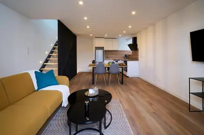 a living room with a couch and a table at Le rempart Scandinave - Triplex au pied de la Cité in Carcassonne