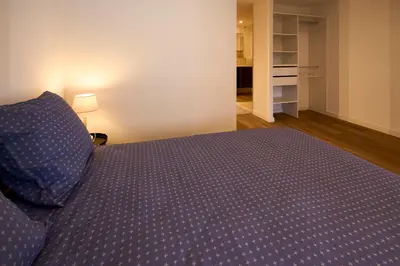a bedroom with a bed with a blue comforter at Le rempart Scandinave - Triplex au pied de la Cité in Carcassonne