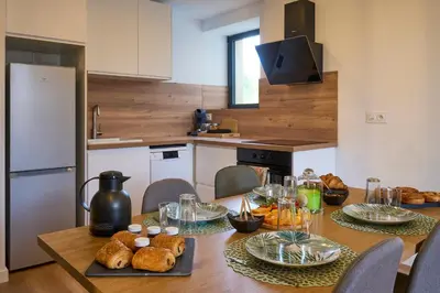 a kitchen with a table with bread and food on it at Le rempart Scandinave - Triplex au pied de la Cité in Carcassonne