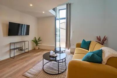 a living room with a couch and a tv at Le rempart Scandinave - Triplex au pied de la Cité in Carcassonne