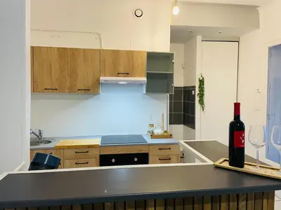 a kitchen with a bottle of wine sitting on a counter at Appartement 3 chambres proche centre ville in Carcassonne