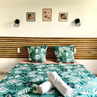 a bed with green sheets and towels on it at Appartement 3 chambres proche centre ville in Carcassonne