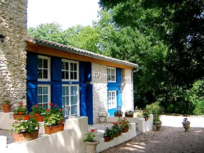 a blue building with potted plants in front of it at Le Clos Sainte Marie - Lampy in Cenne-Monestiès