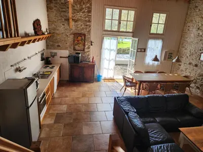 a kitchen and living room with a couch and a table at Le Clos Sainte Marie - Lampy in Cenne-Monestiès