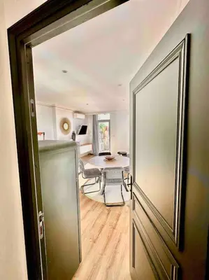 a room with a table and a door leading to a kitchen at Élégance Lauragaise * Wifi * Netflix * Terrasse in Villefranche-de-Lauragais