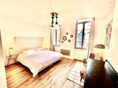 a bedroom with a white bed and a wooden floor at Élégance Lauragaise * Wifi * Netflix * Terrasse in Villefranche-de-Lauragais