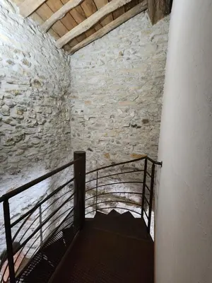 a staircase in a room with a stone wall at Le Clos Sainte Marie - Caune in Cenne-Monestiès