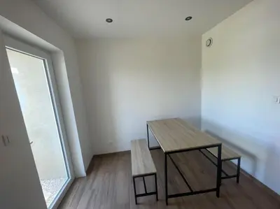a table and a bench in a room with a window at Jiovanni in Rieux-Minervois