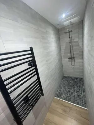 a bathroom with a shower with a tile wall at Jiovanni in Rieux-Minervois