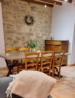 a dining room with a wooden table and chairs at Les jardins du Canal in Sainte-Eulalie
