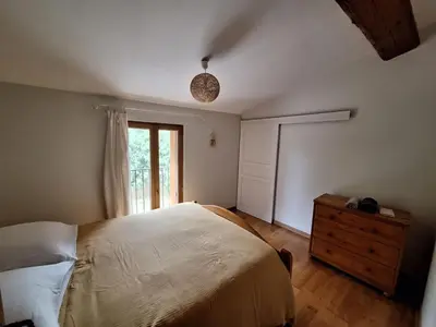 a bedroom with a large bed and a window at Les jardins du Canal in Sainte-Eulalie