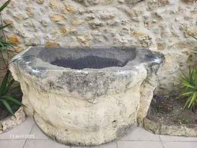 a stone planter sitting in front of a stone wall at Gîte des Vignerons in Salles-d'Aude