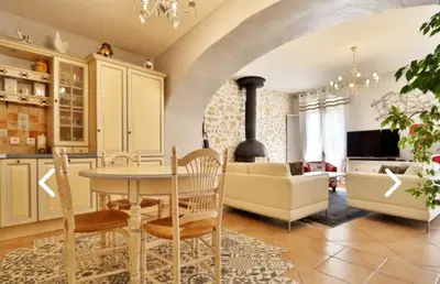 a kitchen and living room with a table and a couch at Gîte des Vignerons in Salles-d'Aude