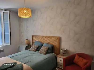 a bedroom with a bed and a chair at Gîte des Vignerons in Salles-d'Aude