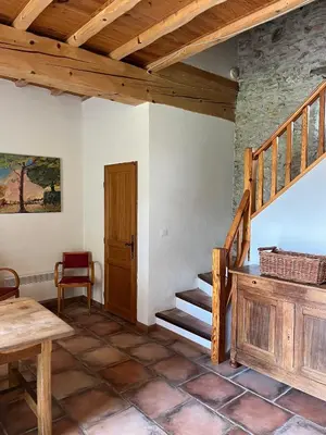 a room with a wooden staircase and a table at Le Clos sainte Marie - Crouzette in Cenne-Monestiès