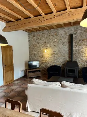 a living room with a couch and a stove at Le Clos sainte Marie - Crouzette in Cenne-Monestiès
