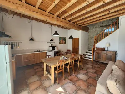 a kitchen and dining room with a wooden table at Le Clos sainte Marie - Crouzette in Cenne-Monestiès