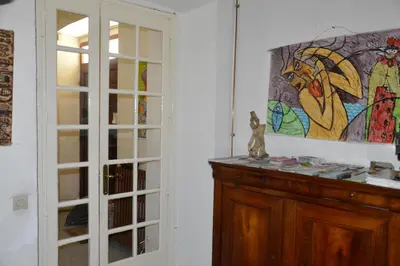 a room with a cabinet and a painting on the wall at Maison d'hôtes La Giraudasse in Soulatgé