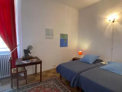 a bedroom with two beds and a table with a lamp at Maison d'hôtes La Giraudasse in Soulatgé