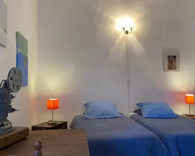 a bedroom with two beds and a clock on the wall at Maison d'hôtes La Giraudasse in Soulatgé