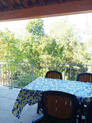 a dining room with a table and a large window at Les Murmures du Lac in Azille