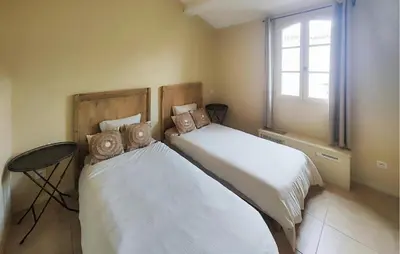 two beds in a room with a window at 2 Bedroom Nice Home In Saint-Laurent-De-La-Ca in Saint-Laurent-de-la-Cabrerisse
