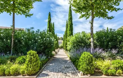a path in a garden with trees and bushes at 2 Bedroom Nice Home In Saint-Laurent-De-La-Ca in Saint-Laurent-de-la-Cabrerisse