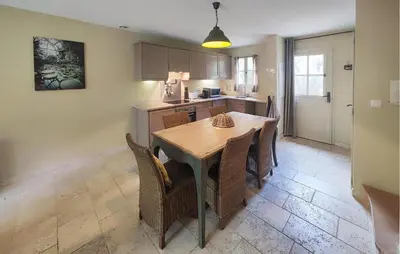a kitchen with a table and chairs in a room at 2 Bedroom Nice Home In Saint-Laurent-De-La-Ca in Saint-Laurent-de-la-Cabrerisse