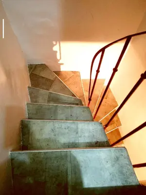 a set of stairs in a building with the sun shining on it at Escapade cœur de ville Narbonne in Narbonne