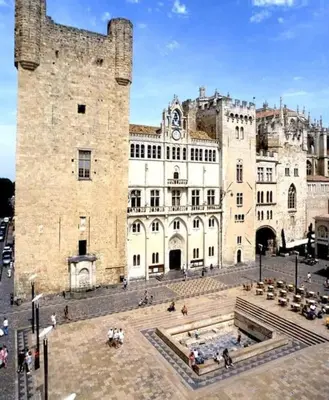 a large stone building with a large tower at Escapade cœur de ville Narbonne in Narbonne