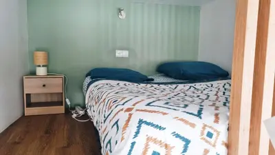 a bedroom with a bed with blue pillows and a night stand at Escapade cœur de ville Narbonne in Narbonne