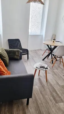 a living room with a couch and a table at Escapade cœur de ville Narbonne in Narbonne