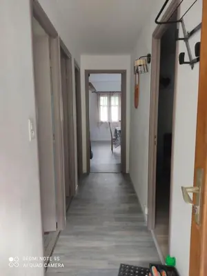 a hallway leading to a room with white walls and wooden floors at gite 4 pers a ROUZE in Rouze