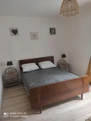 a bedroom with a bed with two night stands and two lamps at gite 4 pers a ROUZE in Rouze