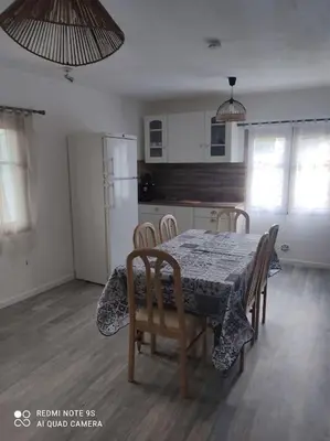 a kitchen with a table and chairs and a kitchen with a refrigerator at gite 4 pers a ROUZE in Rouze