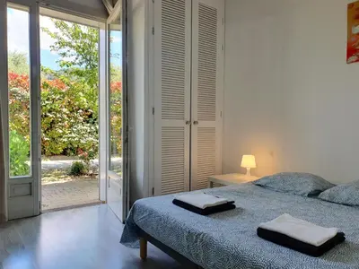 a bedroom with a bed and a sliding glass door at Le Ranch in Oupia