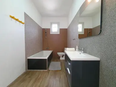 a bathroom with a sink and a tub and a toilet at Le Ranch in Oupia
