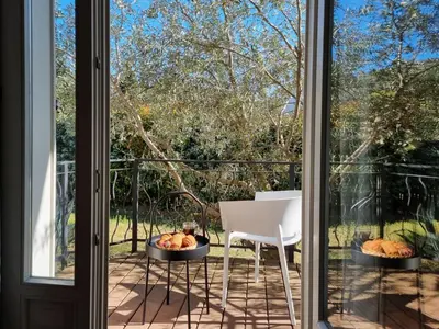 a balcony with a table and a chair and a window at Le Ranch in Oupia