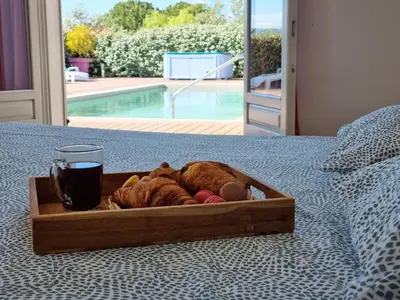 a wooden tray with a drink and stuffed animals on a bed at Le Ranch in Oupia