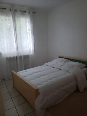 a bed sitting in a bedroom with a window at Maison meublée avec garage in Pamiers