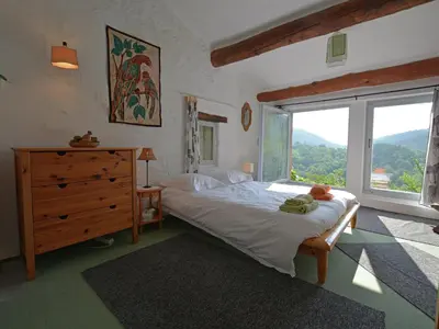 a bedroom with a large bed and a large window at Villa in Pyrenees with Stunning Mountain Views in Fenouillet