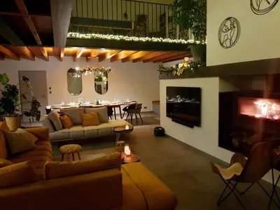 a living room with couches and a dining room at La ferme - Domaine Monbel in Mirepoix